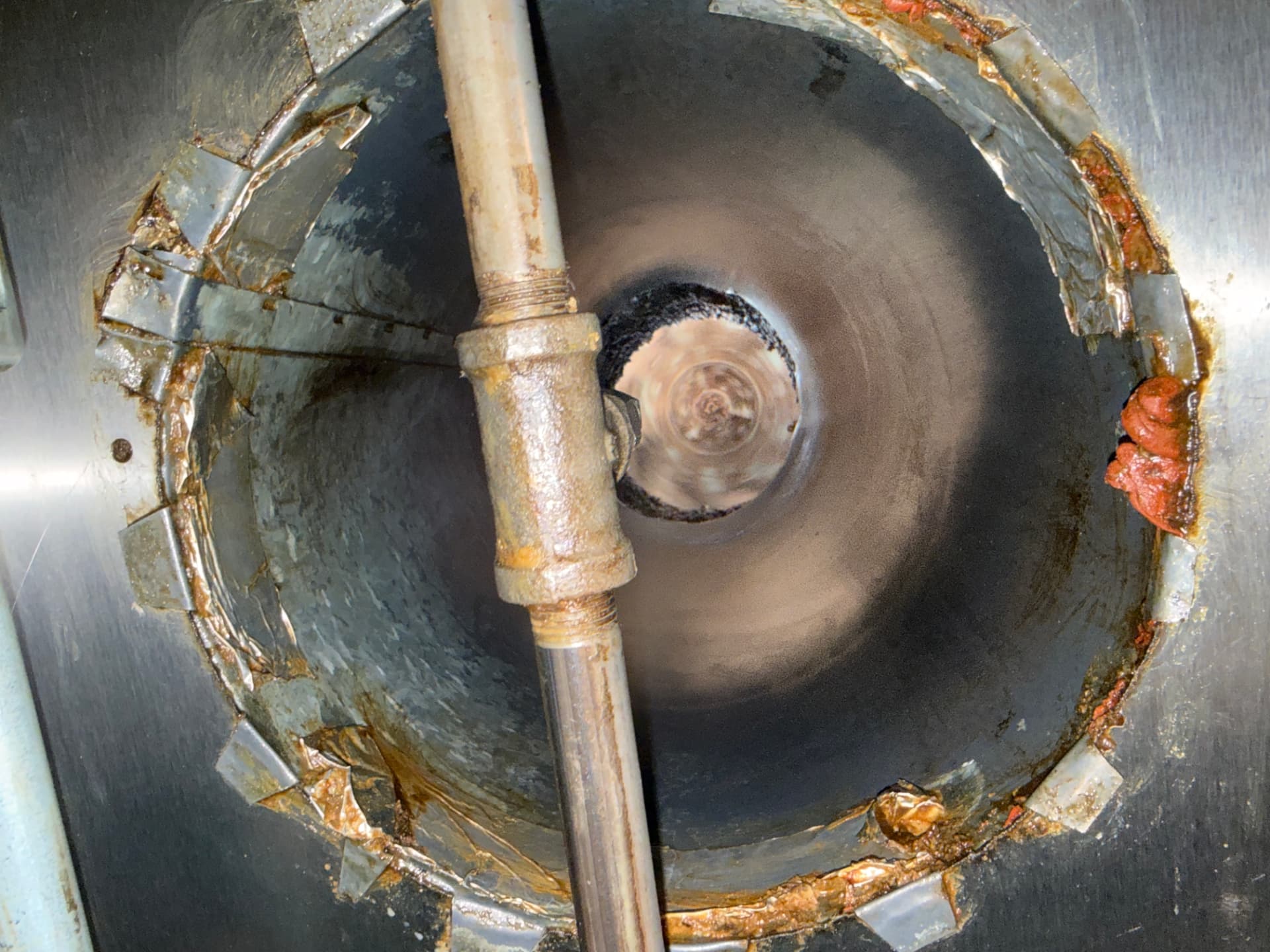 Inside a commercial kitchen exhaust duct and fan housing during a grease cleaning